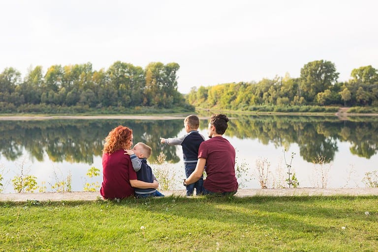 Happy family sits by a lake in St. Cloud, Minnesota