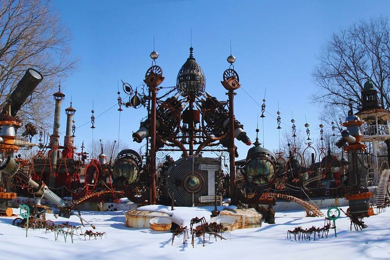 Photo of Dr. Evermore's Forevertron. It is a snowy day with blue sky. Step into a quirky world of imagination at Dr. Evermore's Forevertron in Wisconsin - a majestic scrap metal sculpture park like no other!