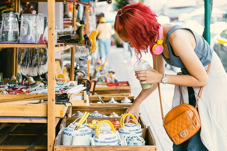 Hip young woman with dyed hair looking at items at the What Cheer Flea Market in Iowa