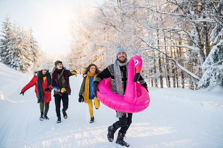 Man in a pink flamingo swim tube and his friends running through winter snow. Discover why our hometown of Winona is called the 'Miami of Minnesota' and how this charming town is warming up the Midwest!