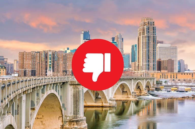 Red thumbs down sign over the city skyline of Minneapolis. Discover the top 10 reasons you should NEVER move to Minneapolis (wink wink) – a city too beautiful, too fun, and too tasty to resist!