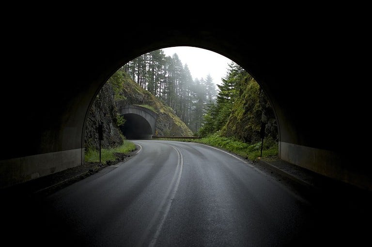 A drive through a tunnel in a wooded area. Similar to the Silver Creek Cliff Tunnel near Two Harbors, MN.