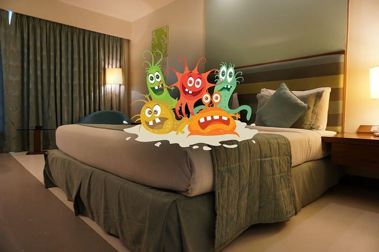 Hotel room bed with cartoon graphic of germs. Get ready for a shocking revelation! Your hotel room might not be as clean as you think! Beware of the 12 germ hotspots in your hotel room!