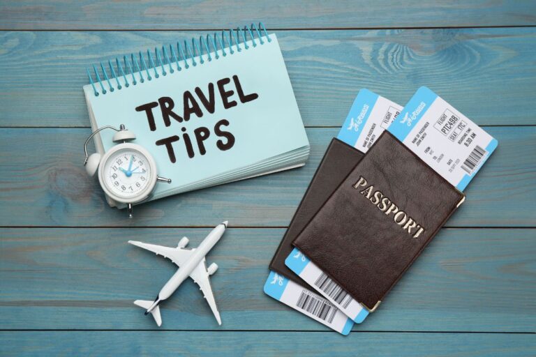 Passports, compass, a small plane toy and a sign that reads "Travel Tips". Ready to fly stress-free? Check out these 25 essential pre-flight tips from a seasoned traveler. Say goodbye to stress and anxiety!
