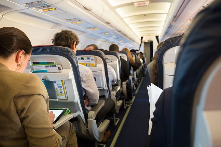 Crowded plane full of people in the seats. Are you tired of being separated from your travel buddy on flights? Well, buckle up because we've got the inside scoop on how to swap seats!