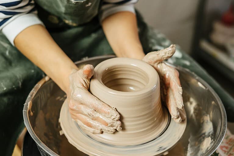 Woman working on a pottery wheel. In this quaint river town, you can discover your inner artist at Iron Bridge Art and Clay, Wabasha, Minnesota's newest creative hub!