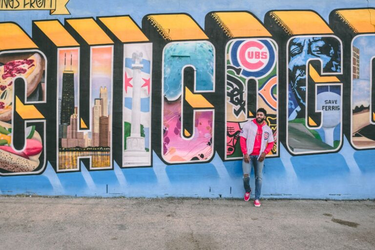 Man poses by Chicago mural. Get blown away by the Windy City's top 13 attractions! From deep-dish pizza to lakefront adventures, Chicago has it all.