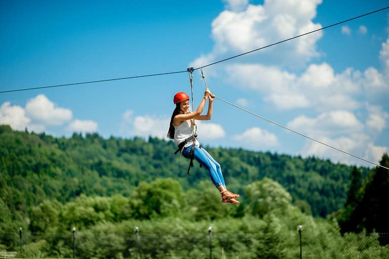 Woman zip lining in Ohio. Embark on an epic adventure through Ohio's great outdoors and discover the state's top-rated thrills your whole family will love!