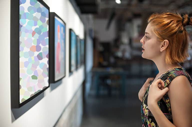 Young woman looking at art at a gallery in Ohio. Your whole family will love going on a fun journey of creative discovery with our guide to the top cultural adventures in Ohio!