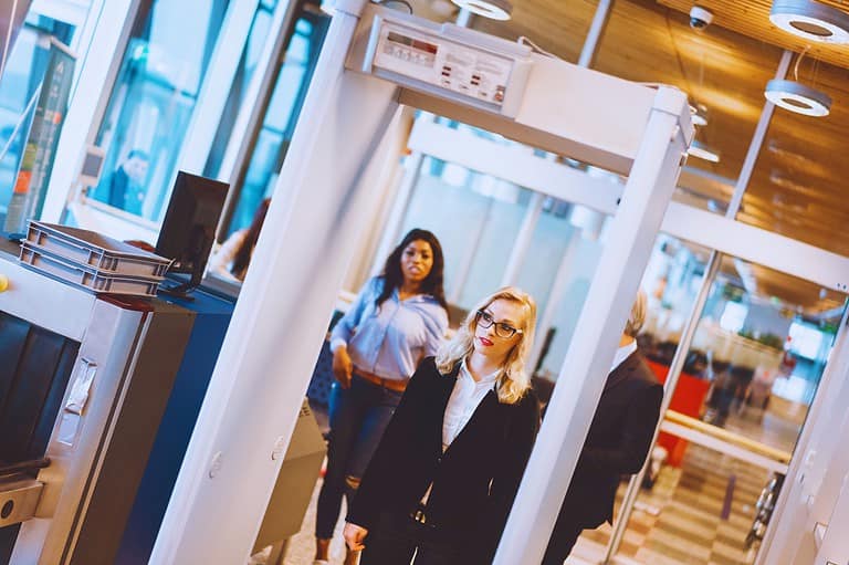 Woman at MSP Airport body scanner machine. Curious about what airport body scanners REALLY see? We've got the scoop on what's happening behind the screen!