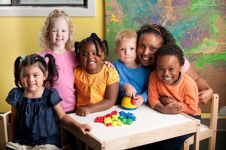 Kindergarten teacher with her kids in classroom. Get ready for giggles galore with these kid-friendly jokes that will have your little one rolling on the floor with laughter!