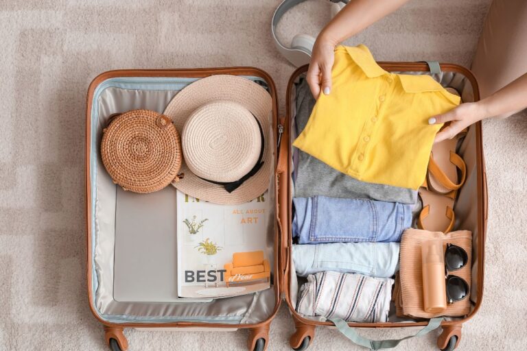 Woman packing her suitcase for vacation. Say goodbye to wrinkled clothes and hello to more space in your suitcase! Learn the art of rolling your clothes for wrinkle-free packing.