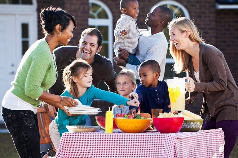 Families laughing at a picnic. Get ready to LOL with our roundup of the most hilarious picnic jokes – perfect for sharing at your next outdoor gathering!