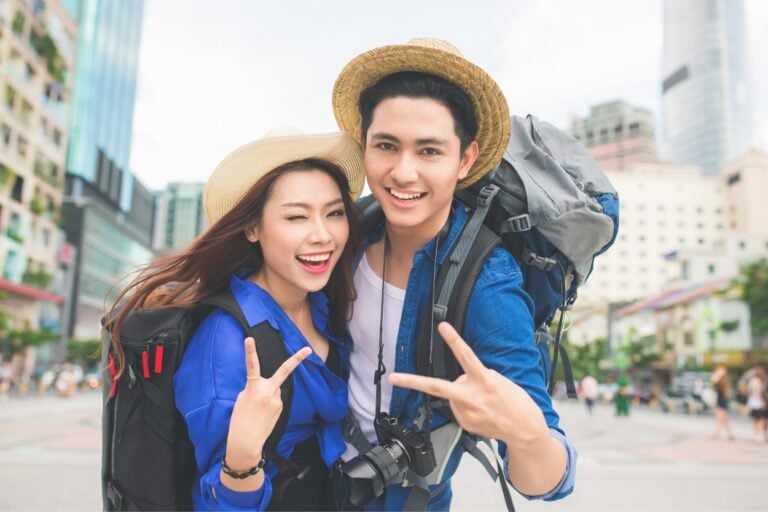 Happy couple traveling during shoulder season. Tired of tourist traps and sky-high prices? Embrace shoulder season travel and experience your dream destination like never before!