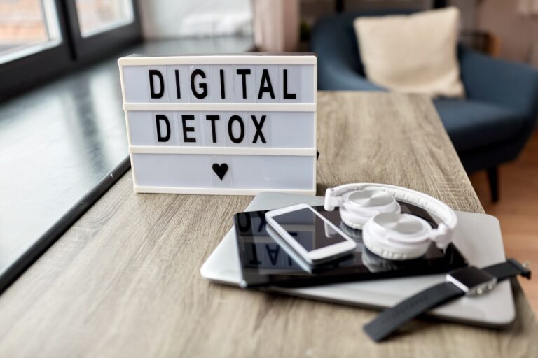 Digital detox sign with devices locked on a table. Discover why more travelers are ditching their devices and embracing a screen-free vacation experience. Could you do it?