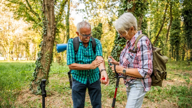 Couple hiking and the man is bit by a mosquito