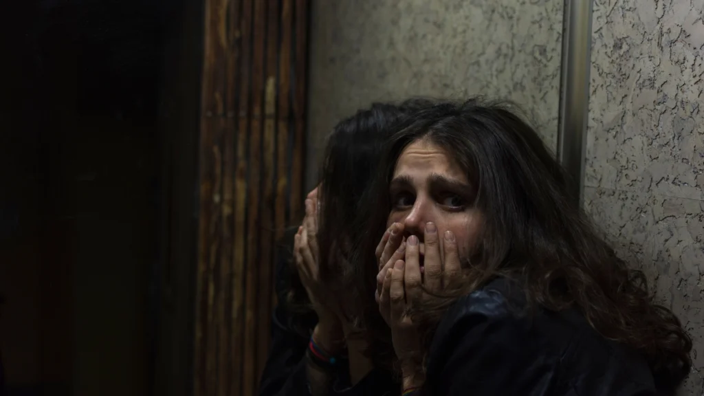 Scared woman in dark home.