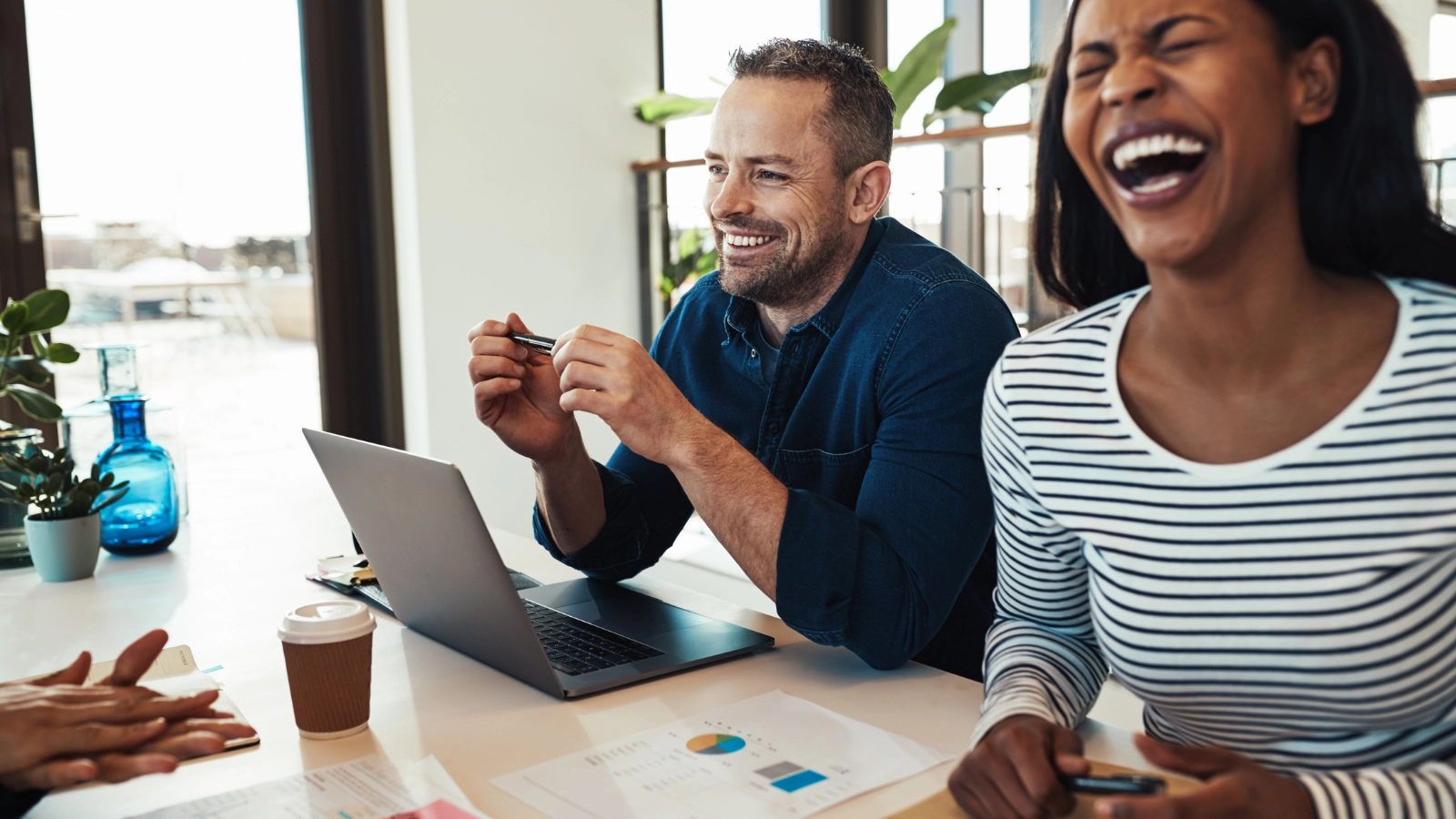 Co-workers laughing in office. Feeling stressed at work? These hilarious jokes about jobs and witty work puns will have you laughing all the way to Friday!