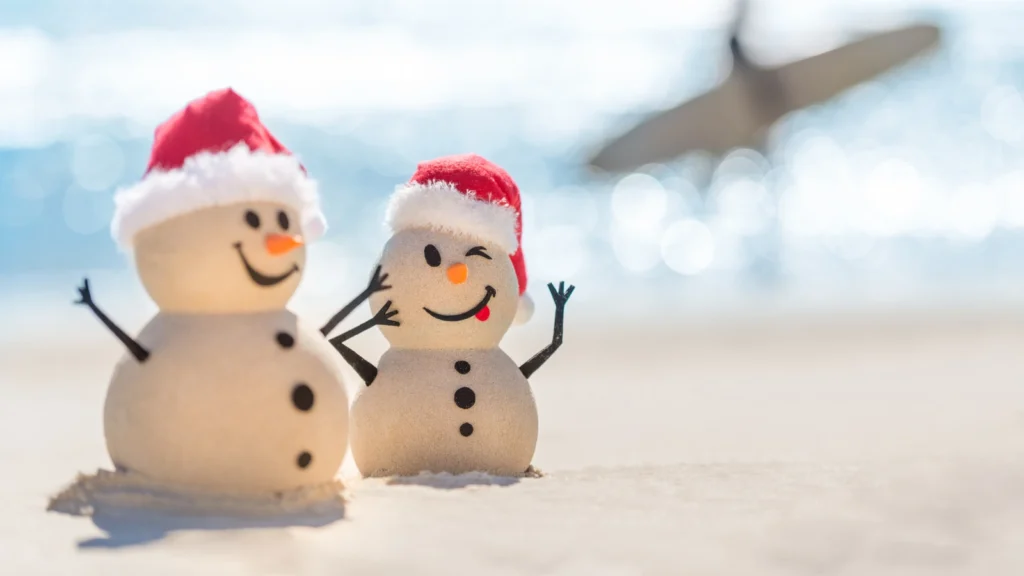 Cute snowmen on beach.